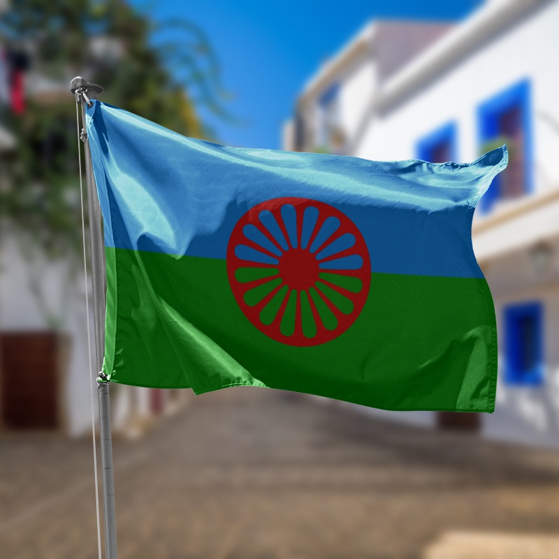 bandera del pueblo gitano azul verde con una rueda de carro roja en el centro